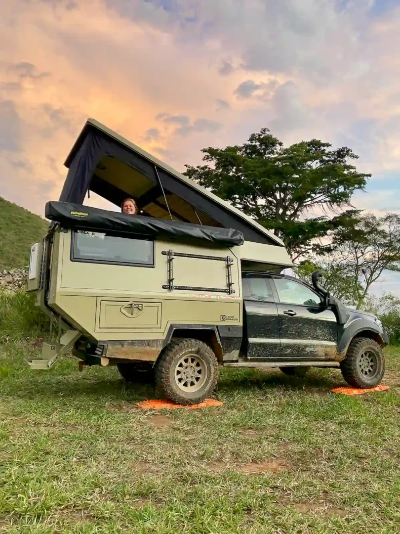 La célula Pioneer para pickup overland con el techo elevable abierto en un paraje natural