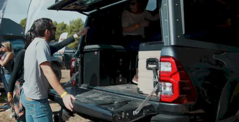 EVENTO EXPO ADN OVERLAND, visitantes en un stand mirando una canopy camper para pick up